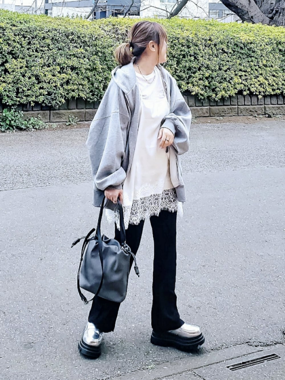 ホワイト系のキャミソール、グレー系のパーカー、ブラック系のその他パンツを着用したレディースの春コーディネートの2枚目の写真