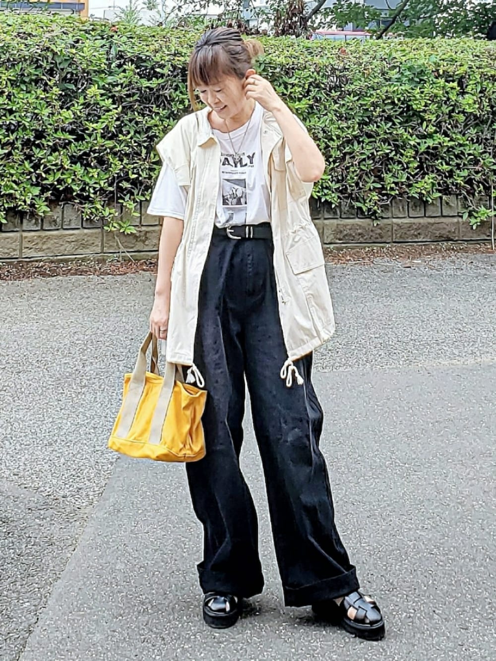 ブラック系のデニムパンツ、ホワイト系のTシャツ/カットソー、ホワイト系のミリタリージャケットを着用したレディースの夏コーディネートの3枚目の写真