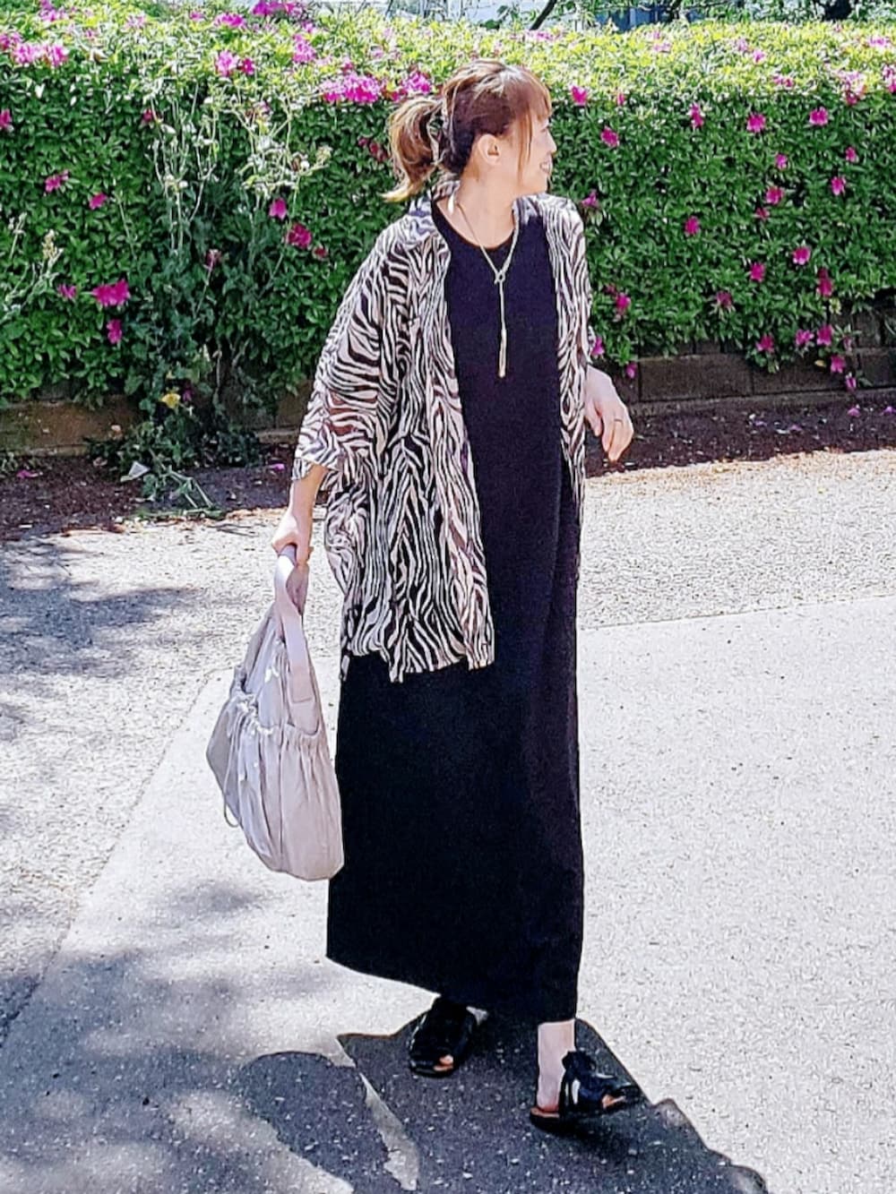 ベージュ系のシャツ/ブラウス、ブラック系のワンピース/ドレス、ブラック系のサンダルを着用したレディースの春コーディネートの2枚目の写真