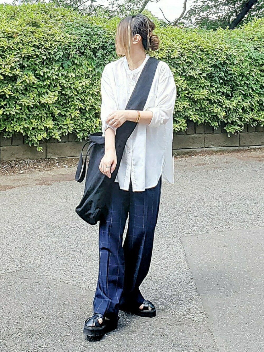 ブラック系のショルダーバッグ、ホワイト系のシャツ/ブラウス、ブルー系のパンツを着用したレディースの夏コーディネートの2枚目の写真