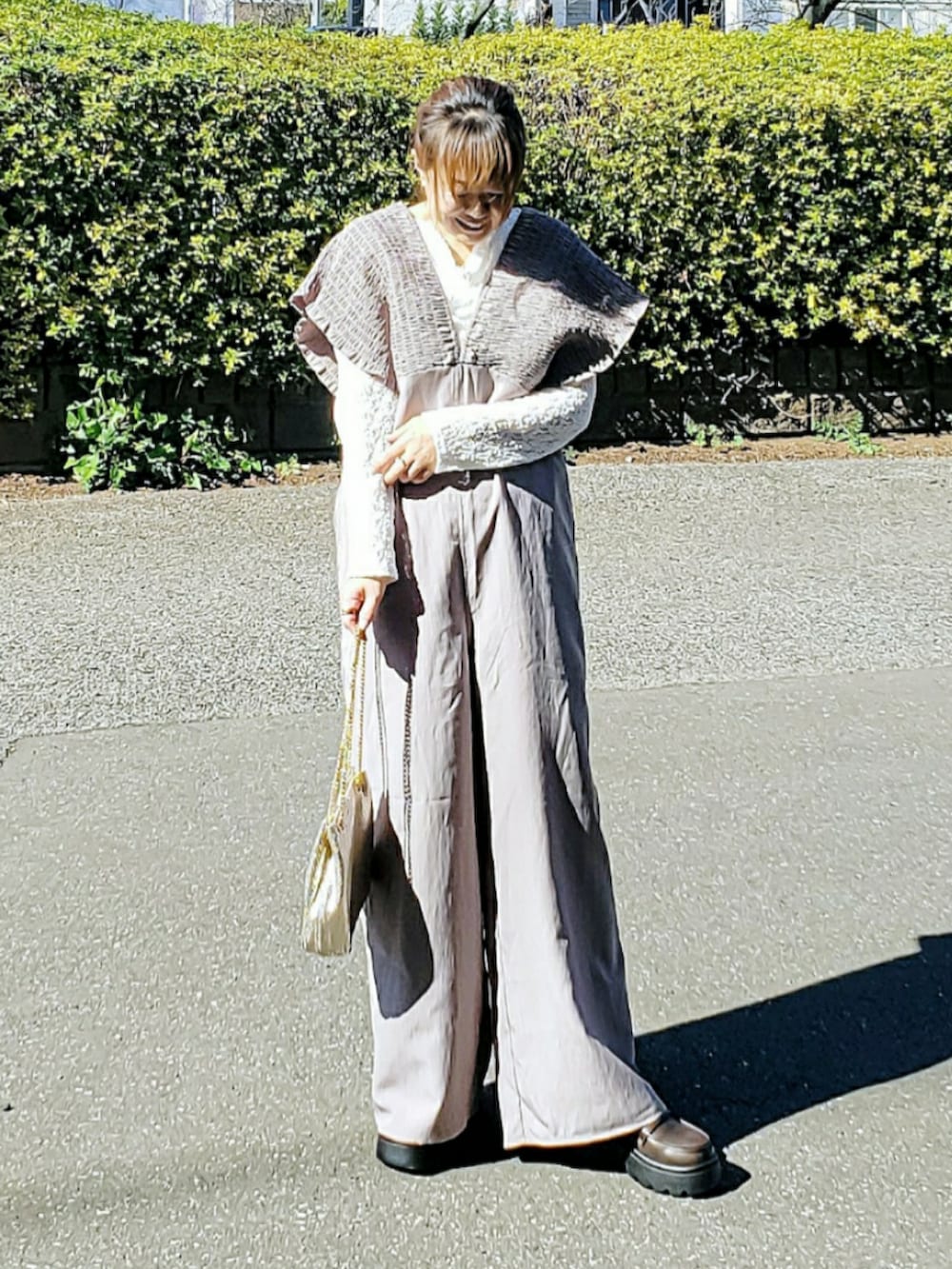 ホワイト系のTシャツ/カットソー、ゴールド系のショルダーバッグ、ブラウン系のローファーを着用したレディースの春コーディネートの2枚目の写真