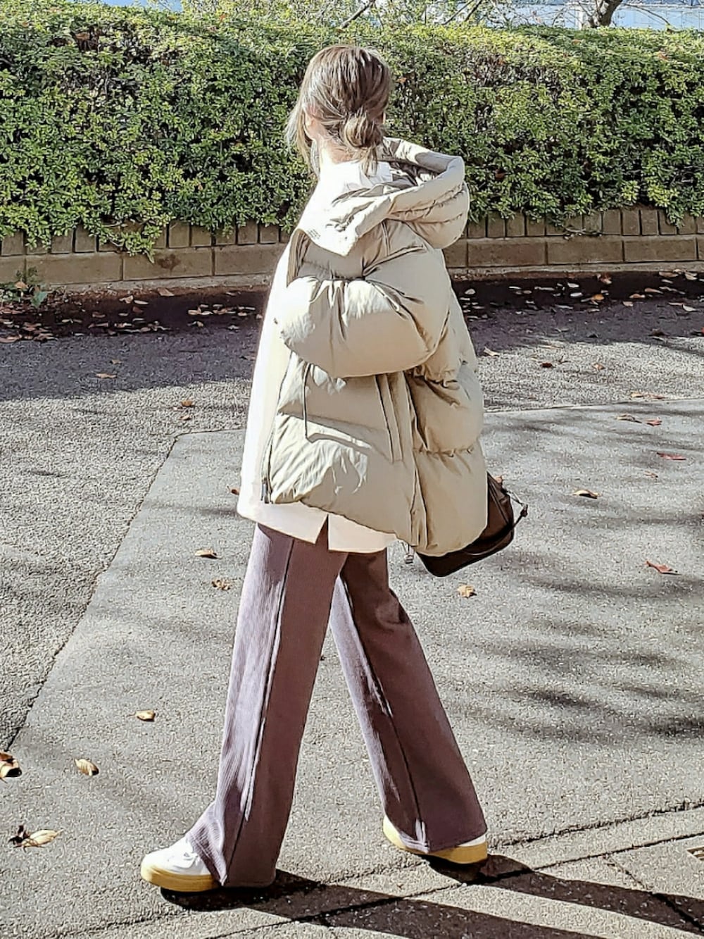 グリーン系のダウンジャケット/コート、ホワイト系のスウェット、グレー系のその他パンツを着用したレディースの冬コーディネートの2枚目の写真