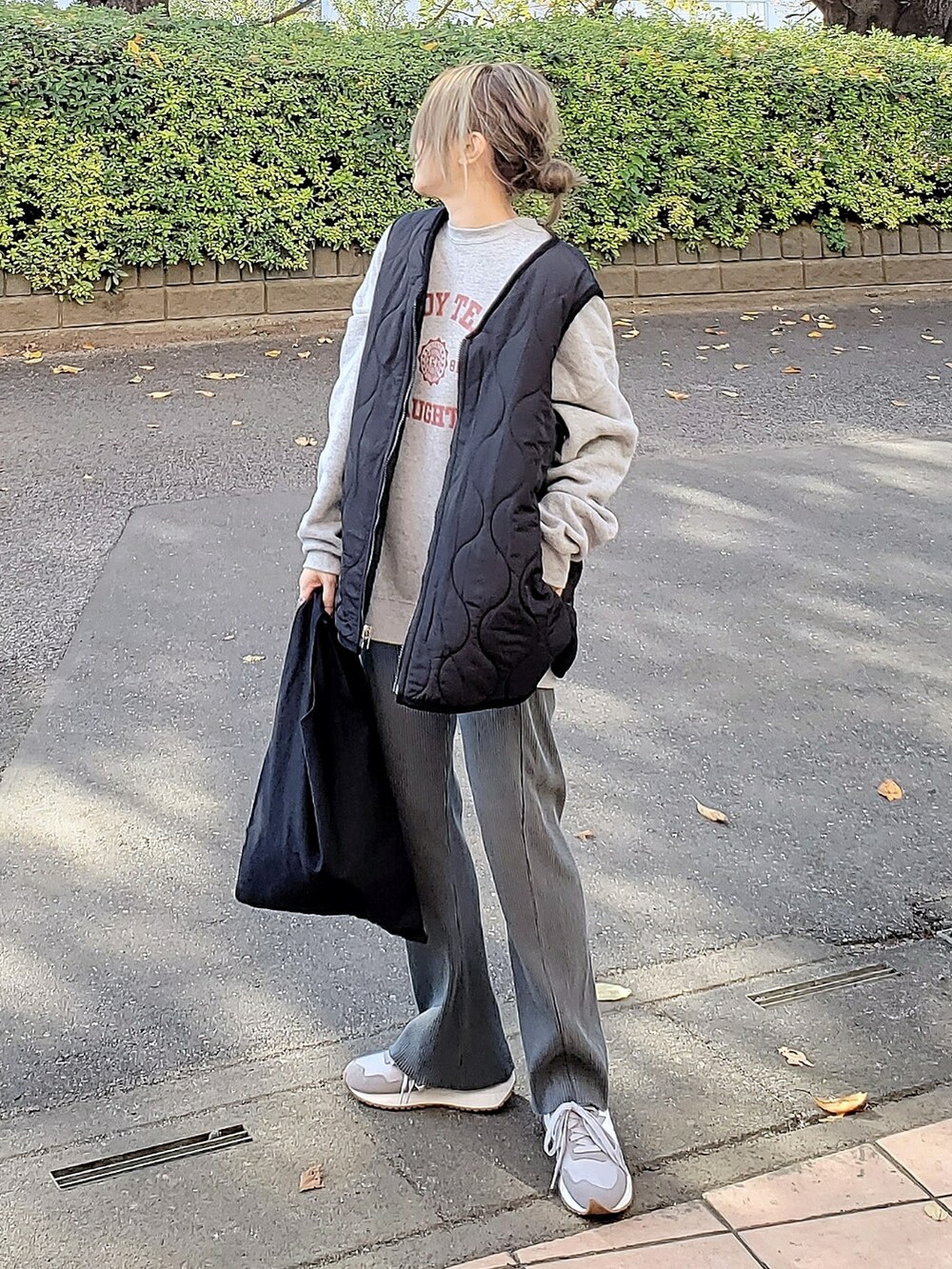 ブラック系のベスト、グレー系のスウェット、グレー系のその他パンツを着用したレディースの秋コーディネートの3枚目の写真