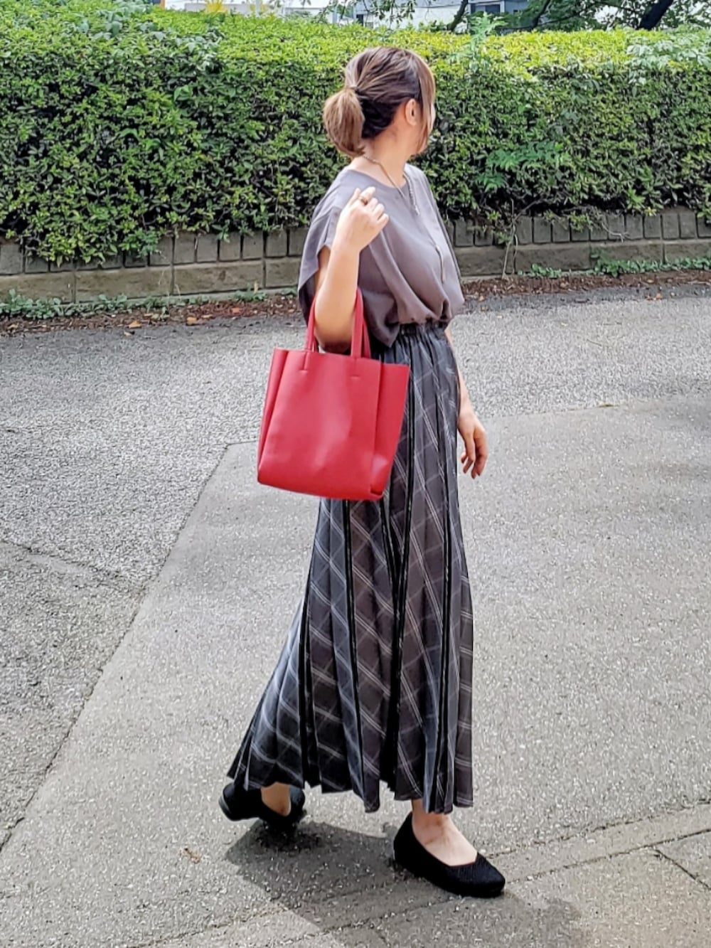 グレー系のスカート、グレー系のTシャツ/カットソー、レッド系のトートバッグを着用したレディースの夏コーディネートの4枚目の写真