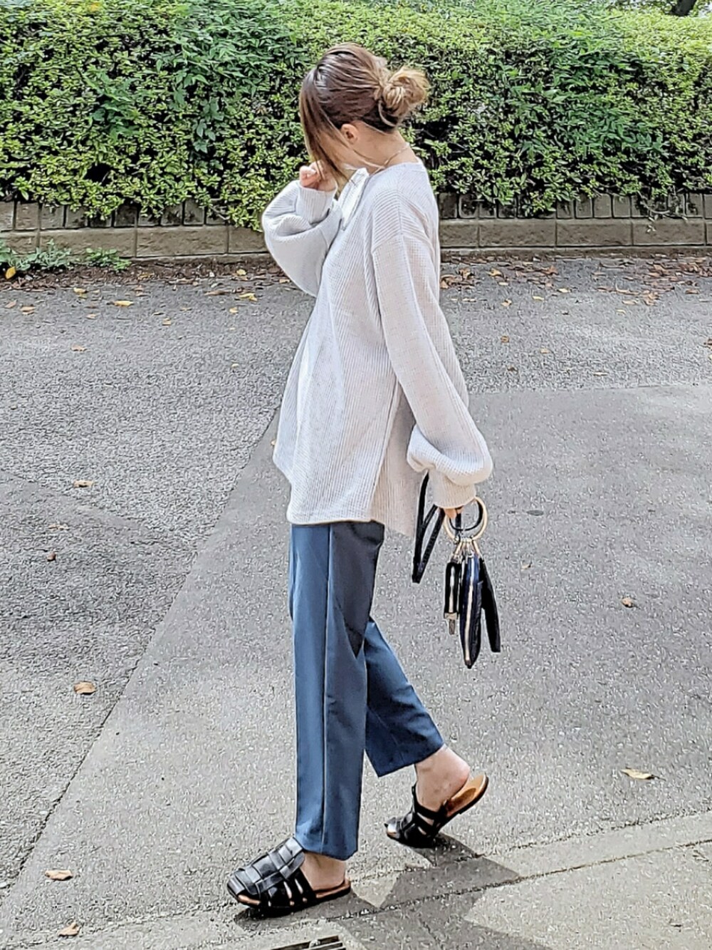 グレー系のスウェット、ブルー系のその他パンツ、ブルー系のショルダーバッグを着用したレディースの秋コーディネートの2枚目の写真