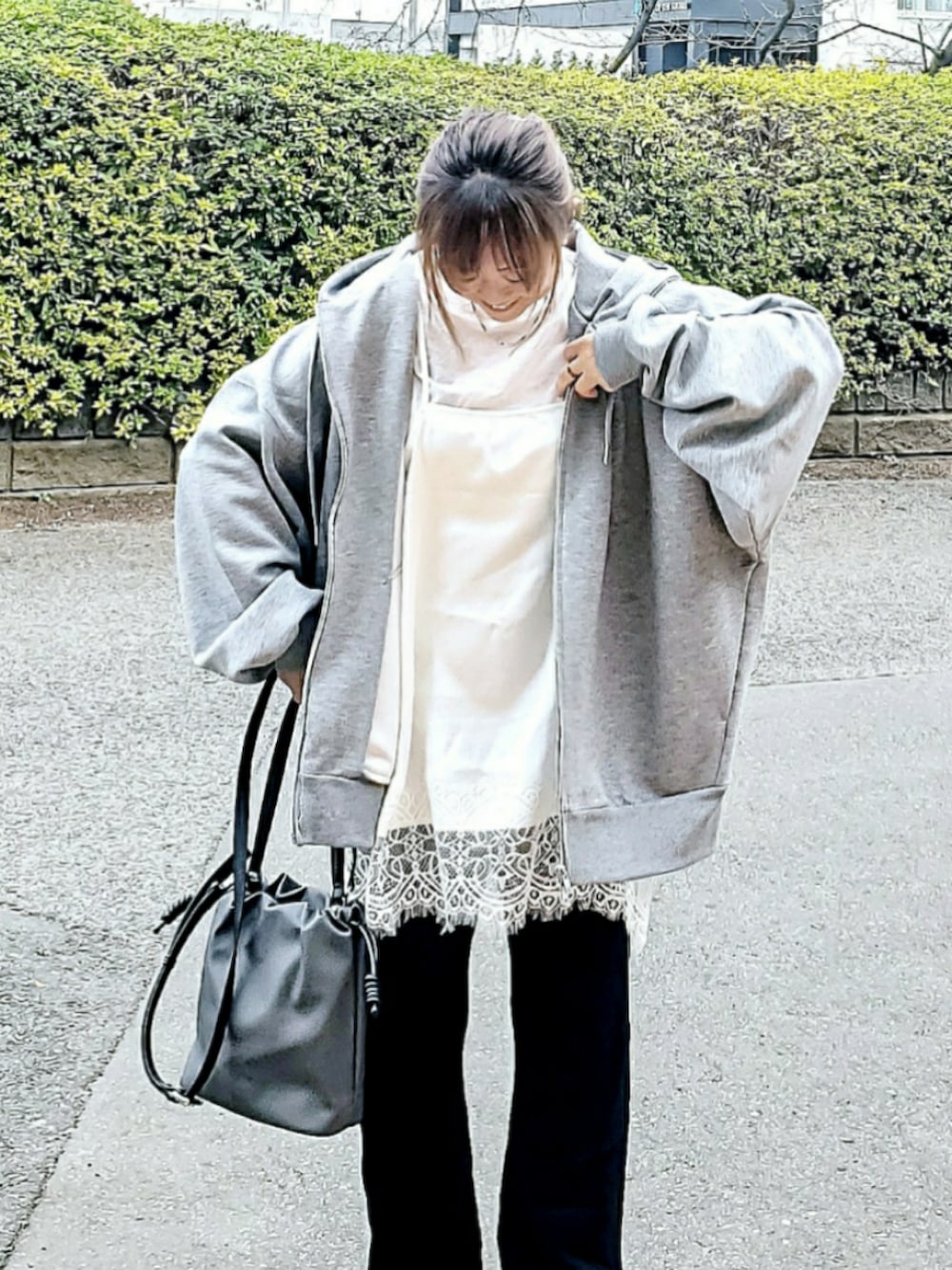 ホワイト系のキャミソール、グレー系のパーカー、ブラック系のその他パンツを着用したレディースの春コーディネートの3枚目の写真