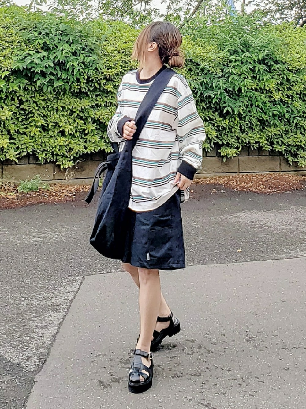 ブラック系のショルダーバッグ、ホワイト系のTシャツ/カットソー、ブラック系のパンツを着用したレディースの春コーディネートの3枚目の写真