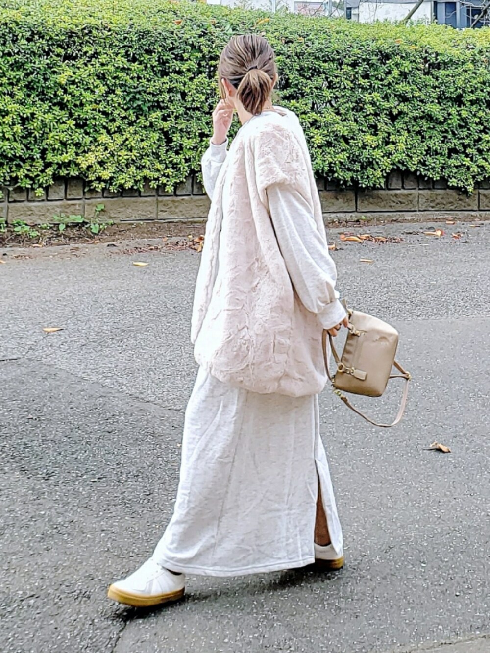 ホワイト系のベスト、ベージュ系のワンピース、ベージュ系のショルダーバッグを着用したレディースの冬コーディネートの3枚目の写真