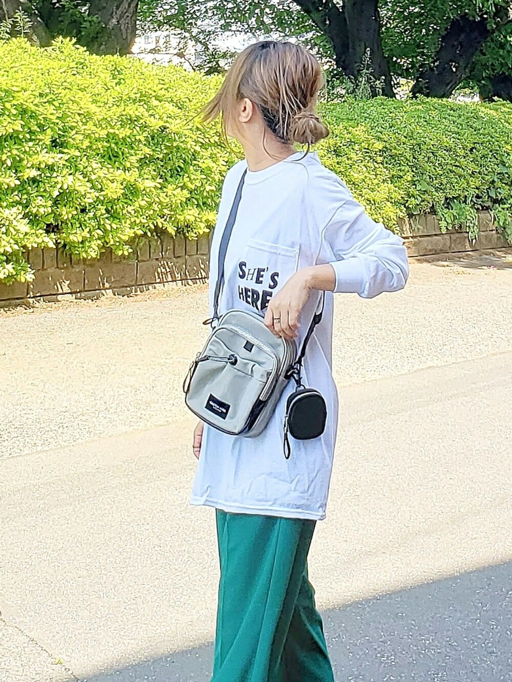 グレー系のショルダーバッグ、ホワイト系のTシャツ/カットソー、グリーン系のその他パンツを着用したレディースの春コーディネートの2枚目の写真