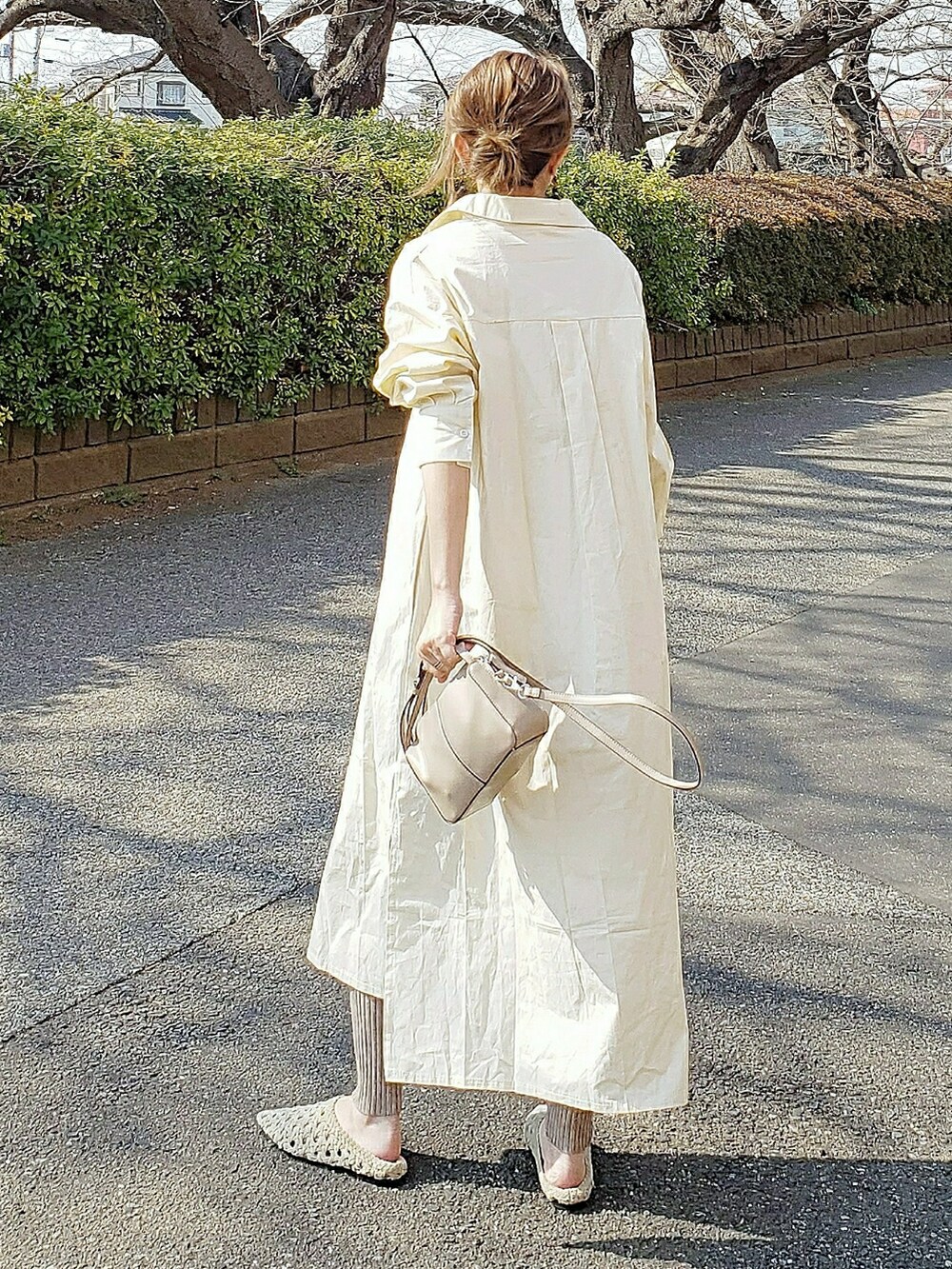 ベージュ系のワンピース、ベージュ系のショルダーバッグ、ベージュ系のサンダルを着用したレディースの春コーディネートの2枚目の写真