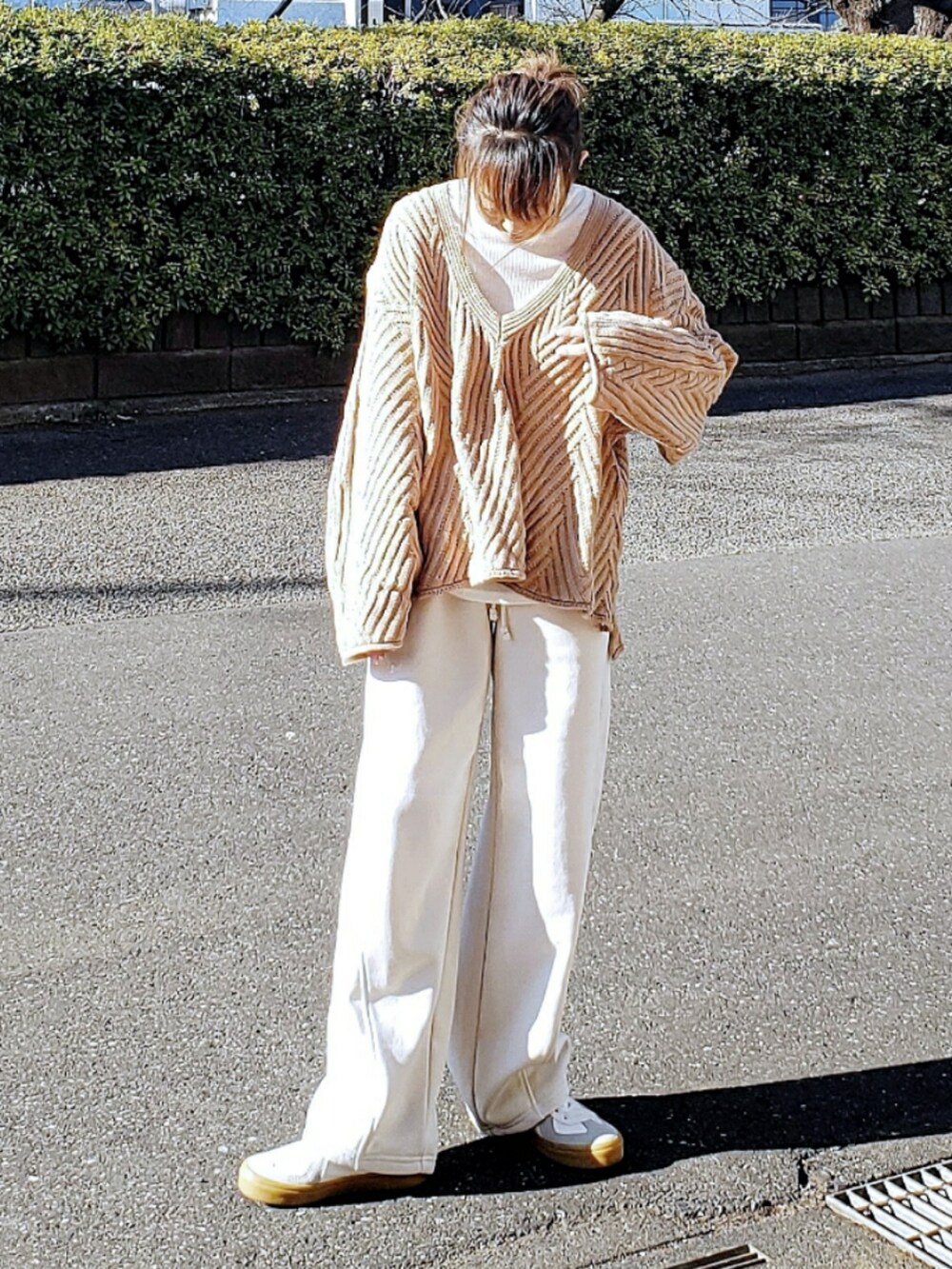 ベージュ系のニット/セーター、ホワイト系のTシャツ/カットソー、ホワイト系のスウェットパンツを着用したレディースの冬コーディネートの2枚目の写真