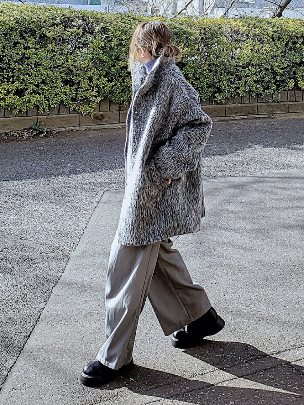 グレー系のジャケット/アウター、ブルー系のニット/セーター、グレー系のスラックスを着用したレディースの冬コーディネートの3枚目の写真