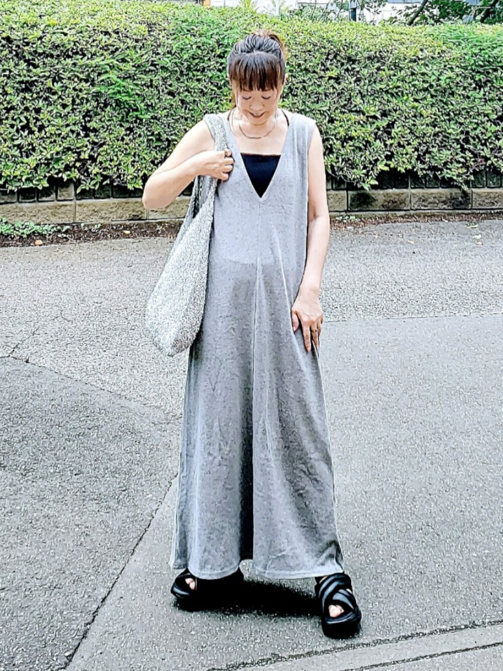 グレー系のワンピース、ブラック系のサンダル、シルバー系のショルダーバッグを着用したレディースの夏コーディネートの2枚目の写真