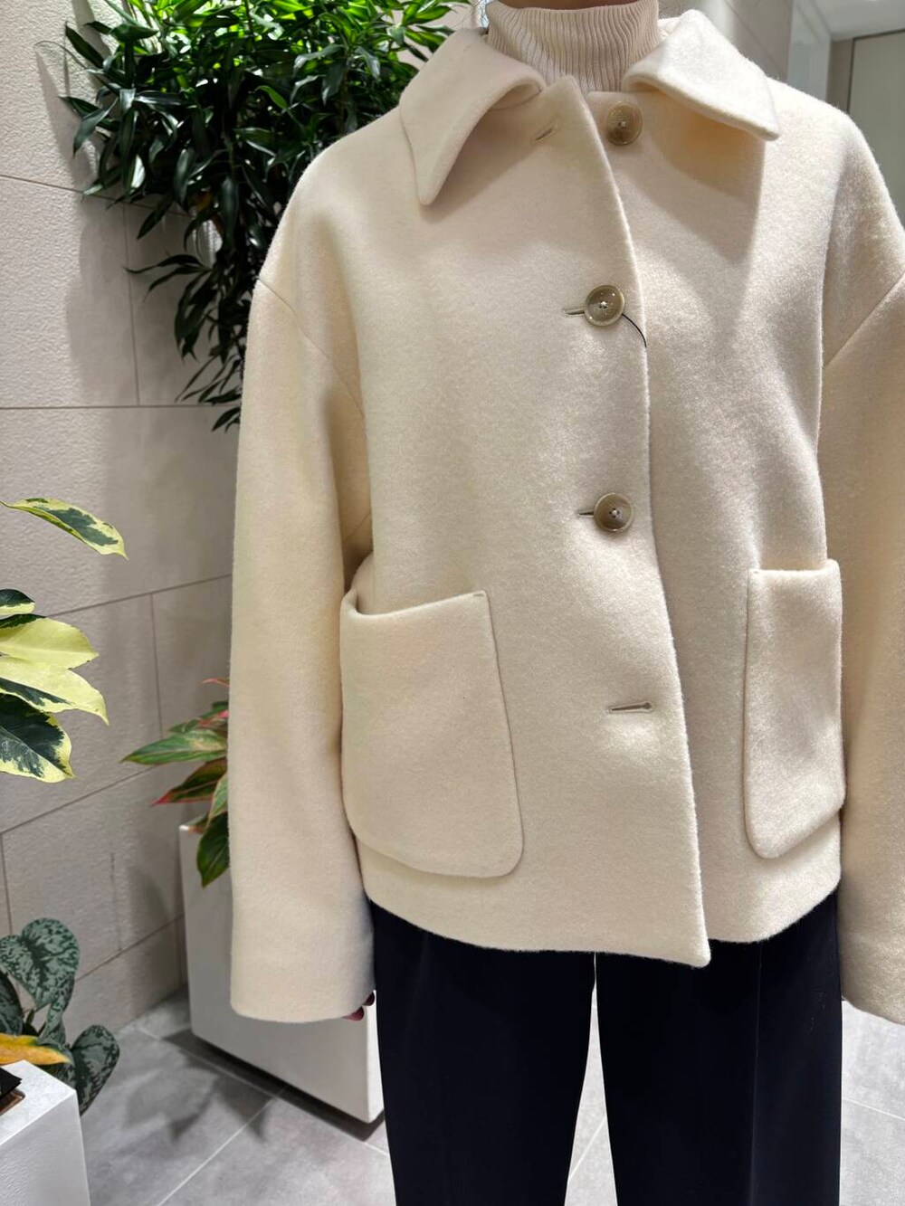 ホワイト系のその他アウター、ブルー系のその他パンツ、ホワイト系のショルダーバッグを着用したレディースの冬コーディネートの3枚目の写真