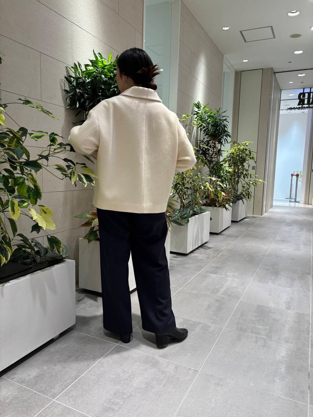 ホワイト系のその他アウター、ブルー系のその他パンツ、ホワイト系のショルダーバッグを着用したレディースの冬コーディネートの2枚目の写真