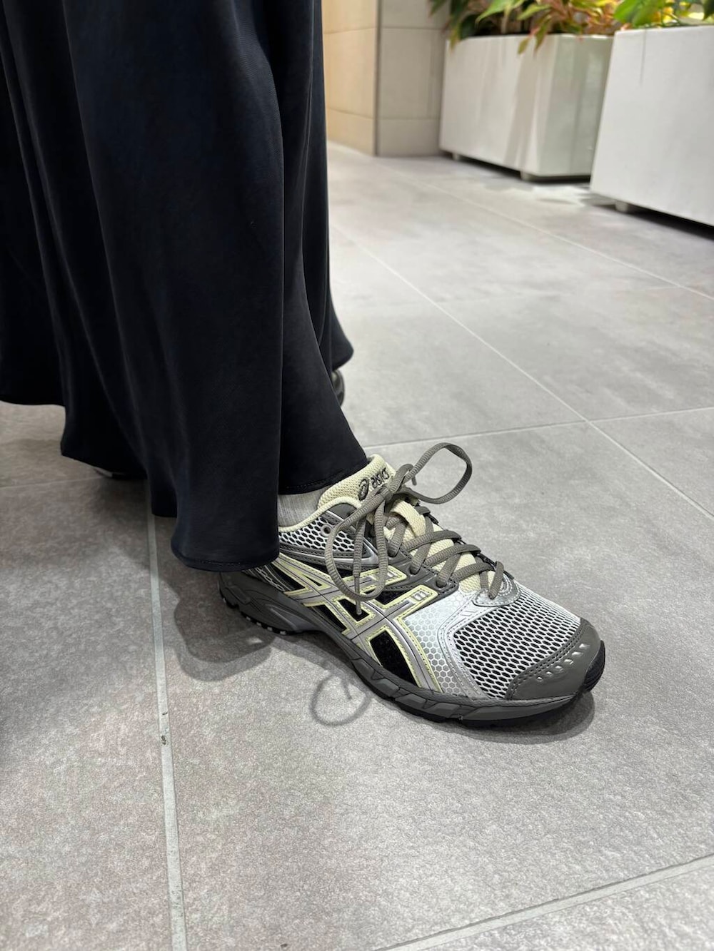 グレー系のスニーカーを着用したレディースの春コーディネートの2枚目の写真