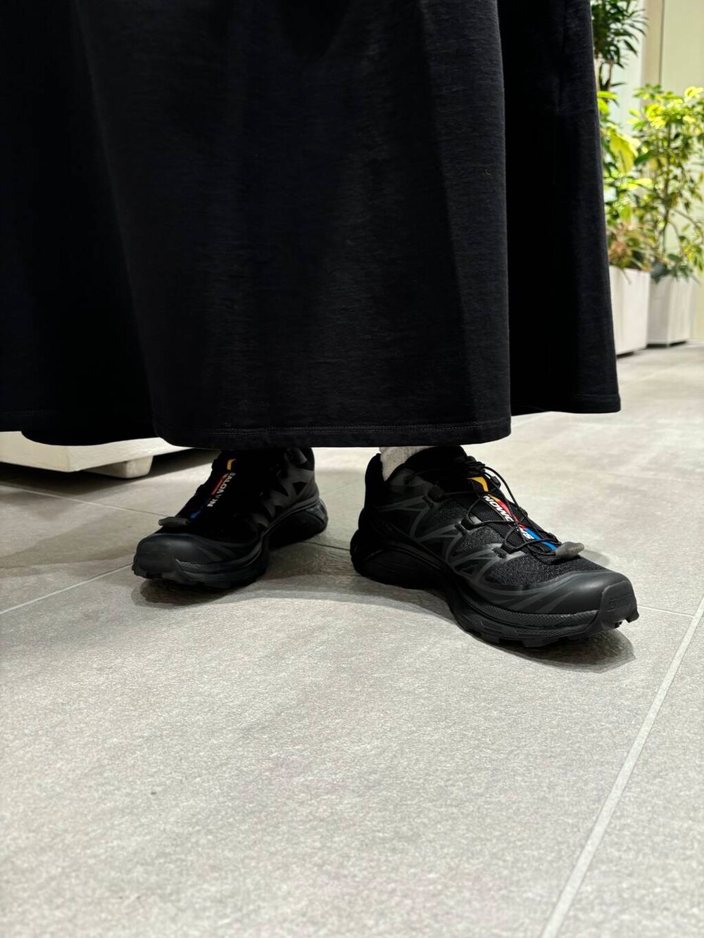 ホワイト系のタンクトップ、ブラック系のスニーカー、ブラック系のワンピースを着用したレディースの夏コーディネートの2枚目の写真