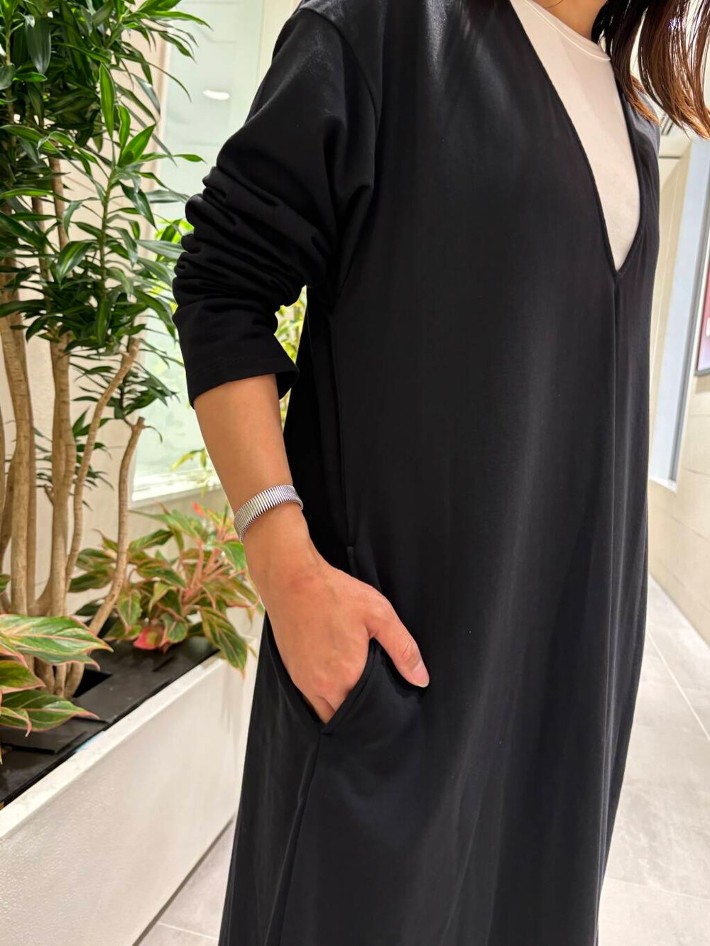 ホワイト系のタンクトップ、ブラック系のスニーカー、ブラック系のワンピースを着用したレディースの夏コーディネートの4枚目の写真