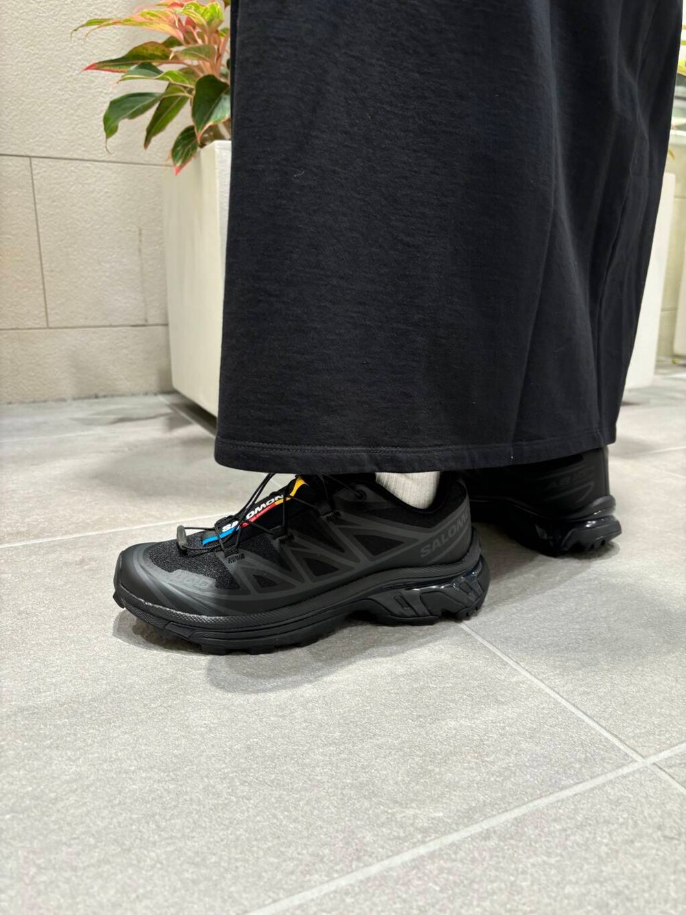 ホワイト系のタンクトップ、ブラック系のスニーカー、ブラック系のワンピースを着用したレディースの夏コーディネートの3枚目の写真