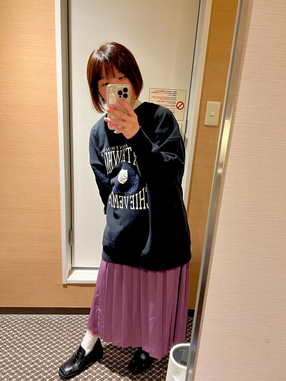 ブラック系のスウェット、ブラック系のローファー、パープル系のスカートを着用したレディースの春コーディネートの2枚目の写真