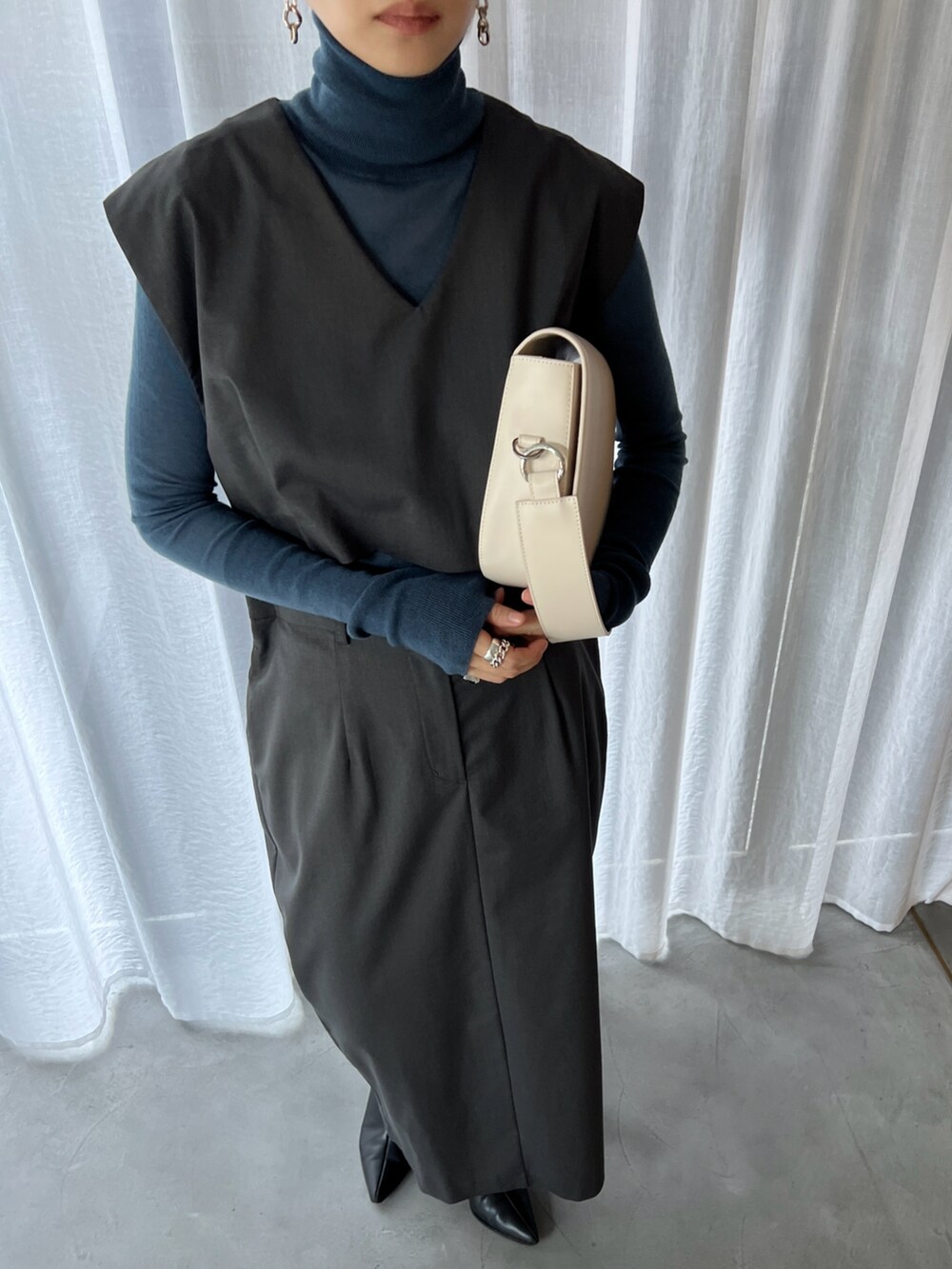 ホワイト系のショルダーバッグ、グレー系のワンピースを着用したレディースの冬コーディネートの2枚目の写真