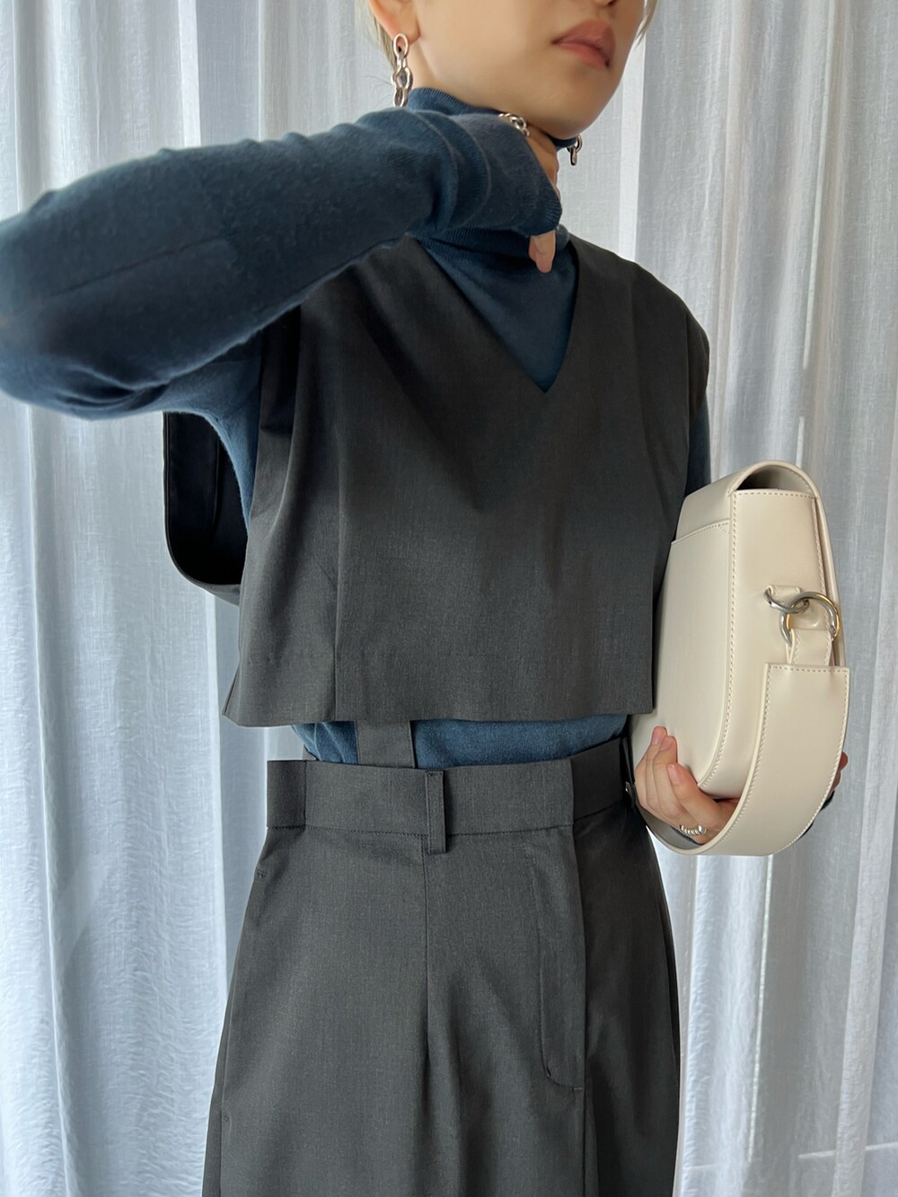 ホワイト系のショルダーバッグ、グレー系のワンピースを着用したレディースの冬コーディネートの3枚目の写真