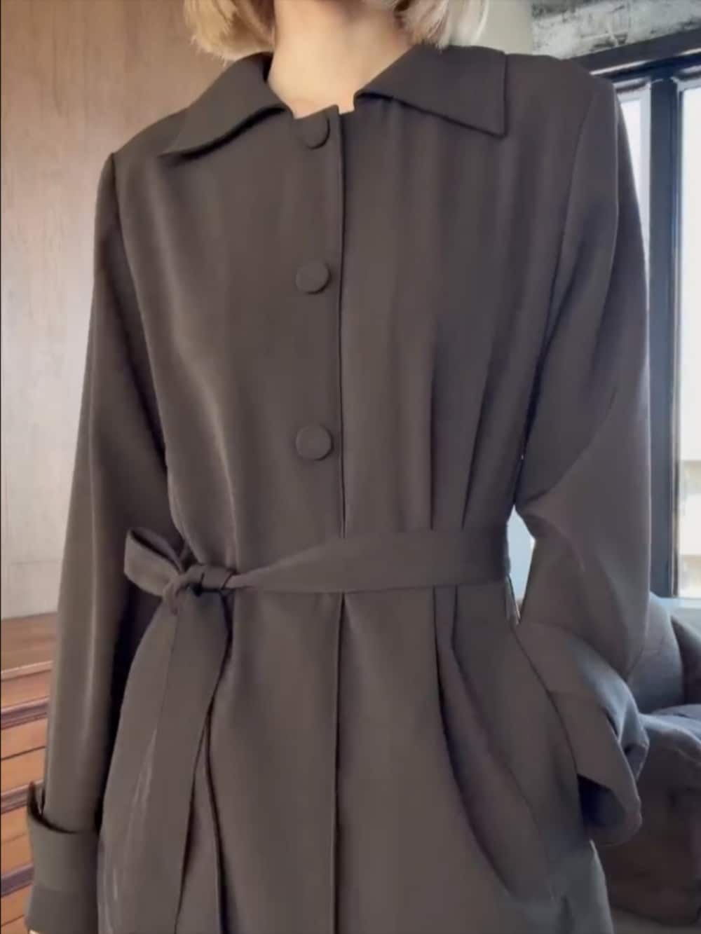 ブラウン系のドレスを着用したレディースの冬コーディネートの2枚目の写真