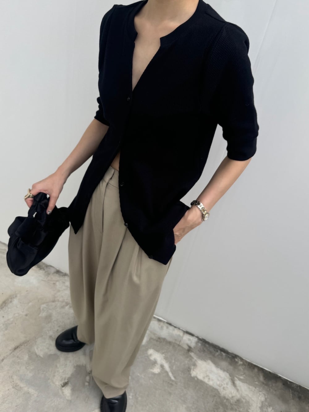 ブラック系のTシャツ/カットソー、ベージュ系のスラックスを着用したレディースの夏コーディネートの3枚目の写真