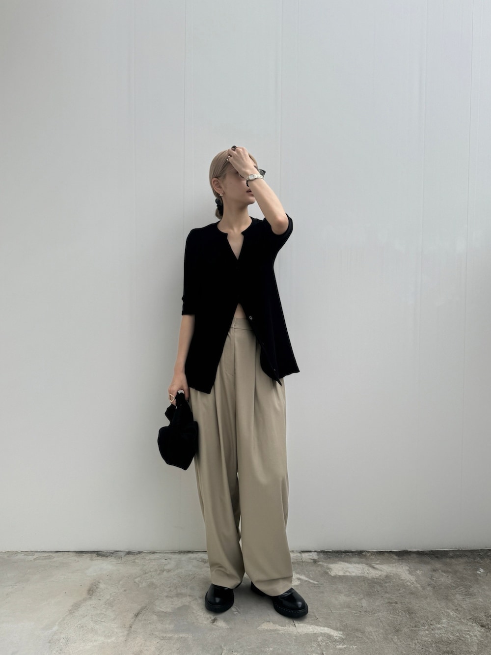 ブラック系のTシャツ/カットソー、ベージュ系のスラックスを着用したレディースの夏コーディネートの2枚目の写真