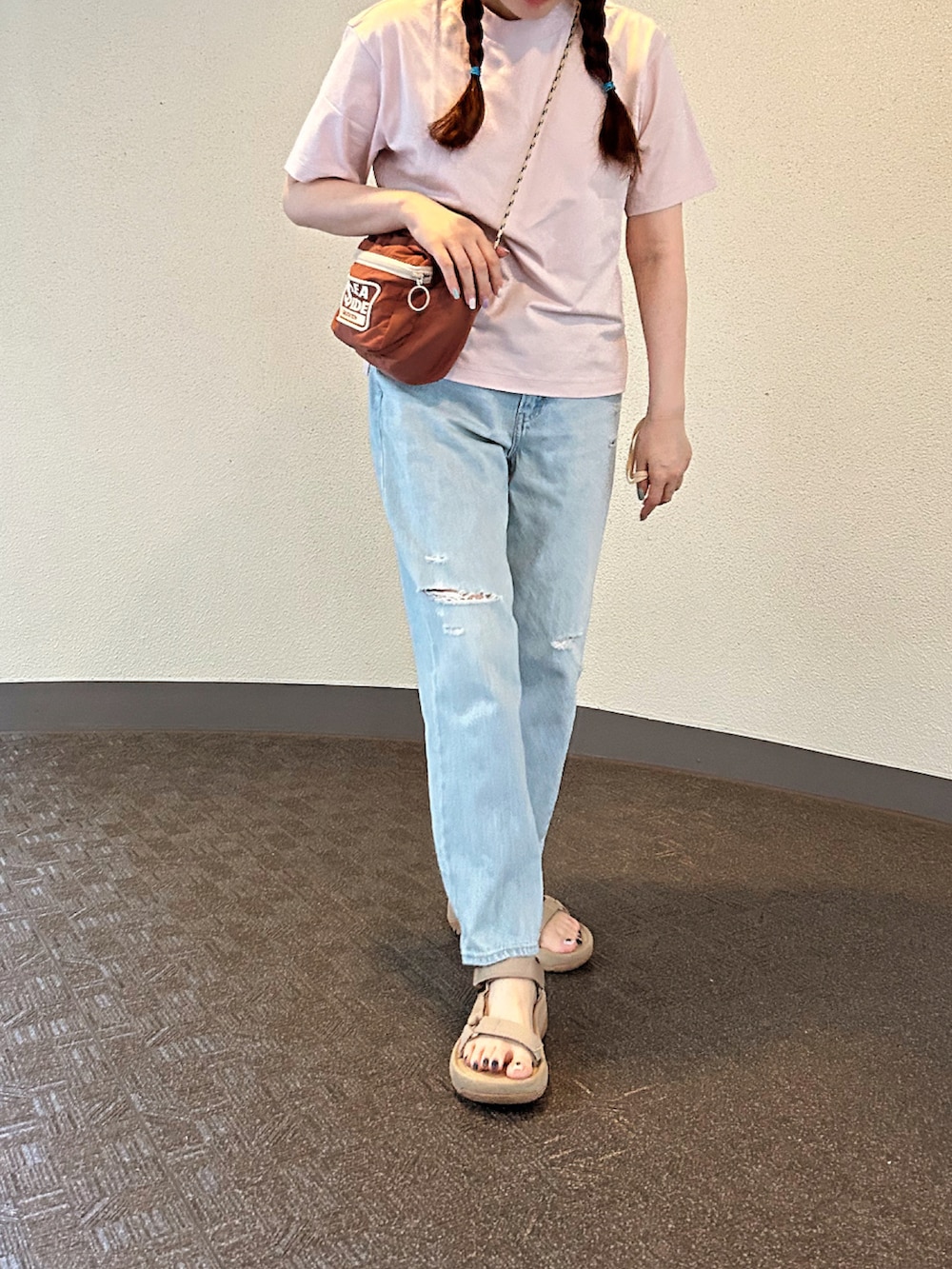 ピンク系のTシャツ/カットソー、ピンク系のショルダーバッグ、ブルー系のデニムパンツを着用したレディースの夏コーディネートの3枚目の写真