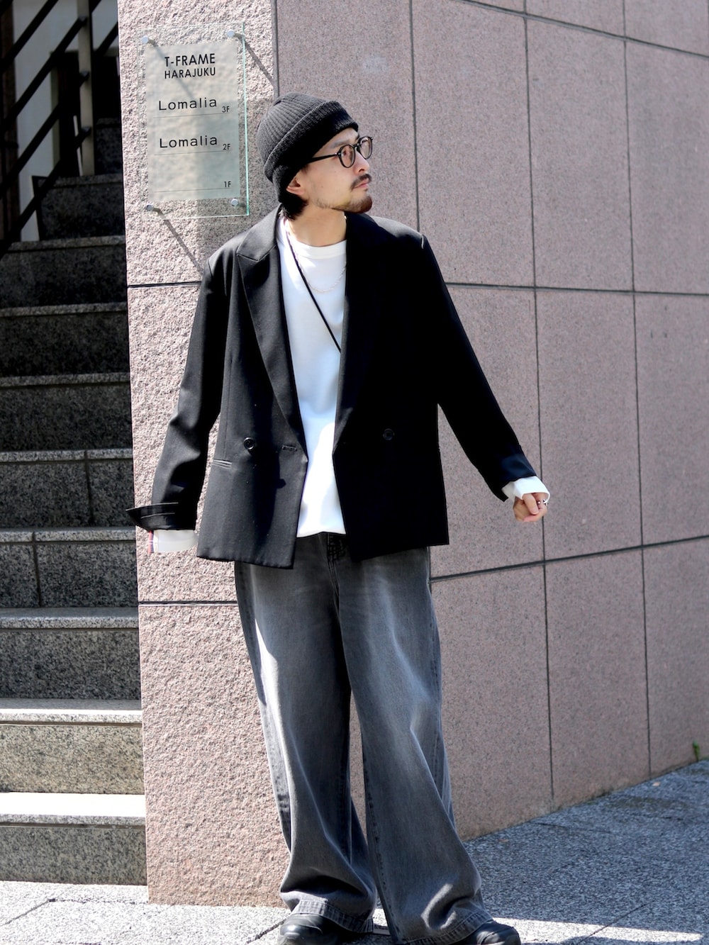 ブラック系のテーラードジャケット、ブラック系のデニムパンツ、ホワイト系のTシャツ/カットソーを着用したメンズの春コーディネートの2枚目の写真