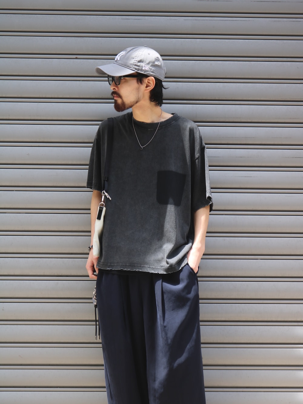 ブルー系のその他パンツ、ブラック系のTシャツ/カットソー、ホワイト系のショルダーバッグを着用したメンズの夏コーディネートの3枚目の写真