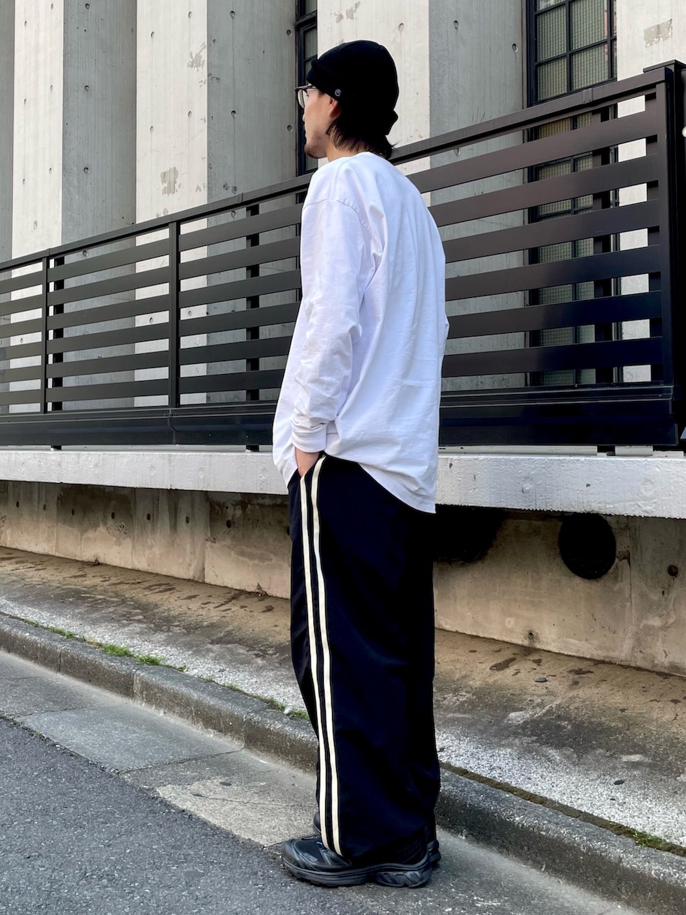 ブラック系のその他パンツ、その他のTシャツ/カットソー、ブラック系のスニーカーを着用したメンズの春コーディネートの3枚目の写真