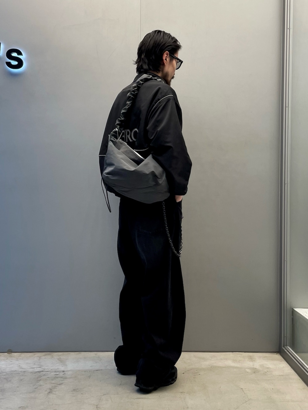 ブラック系のデニムパンツ、グレー系のショルダーバッグ、ブラック系のブルゾンを着用したメンズの夏コーディネートの2枚目の写真