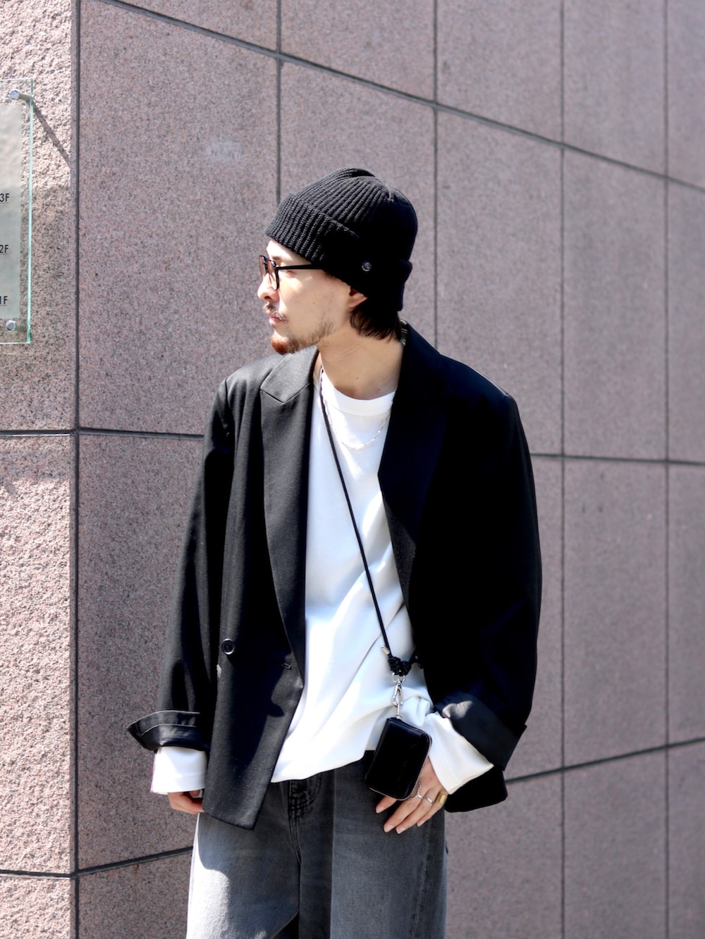 ブラック系のテーラードジャケット、ブラック系のデニムパンツ、ホワイト系のTシャツ/カットソーを着用したメンズの春コーディネートの3枚目の写真