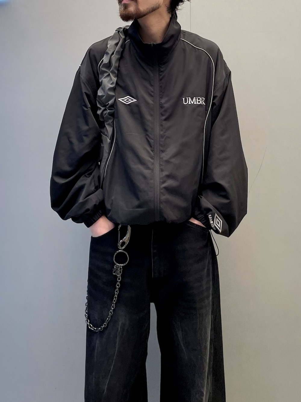 ブラック系のデニムパンツ、グレー系のショルダーバッグ、ブラック系のブルゾンを着用したメンズの夏コーディネートの3枚目の写真