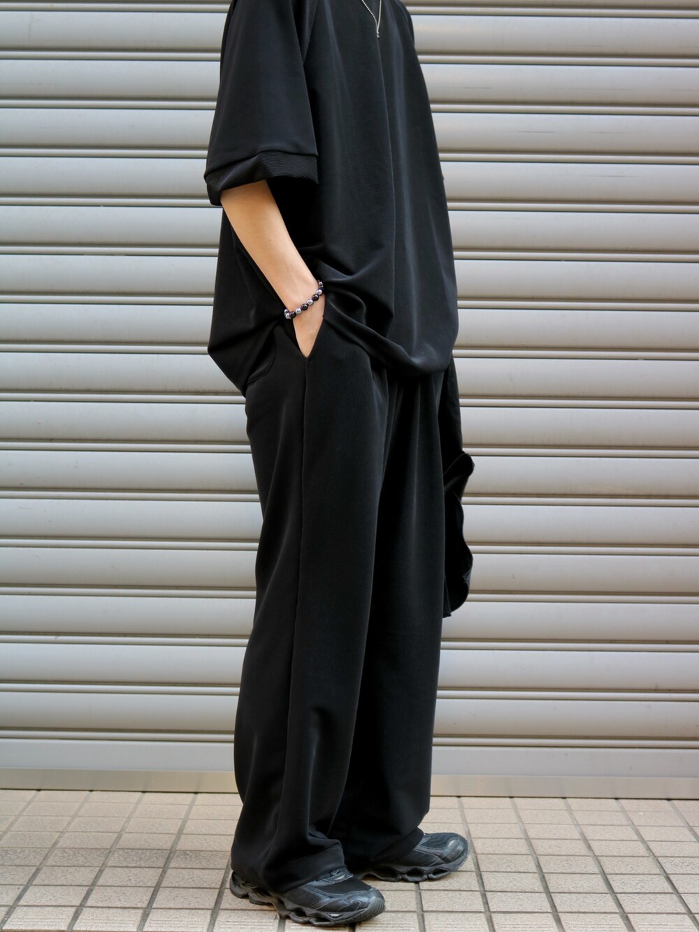 ブラック系のTシャツ/カットソー、ブラック系のトートバッグ、ブラック系のスラックスを着用したメンズの夏コーディネートの6枚目の写真