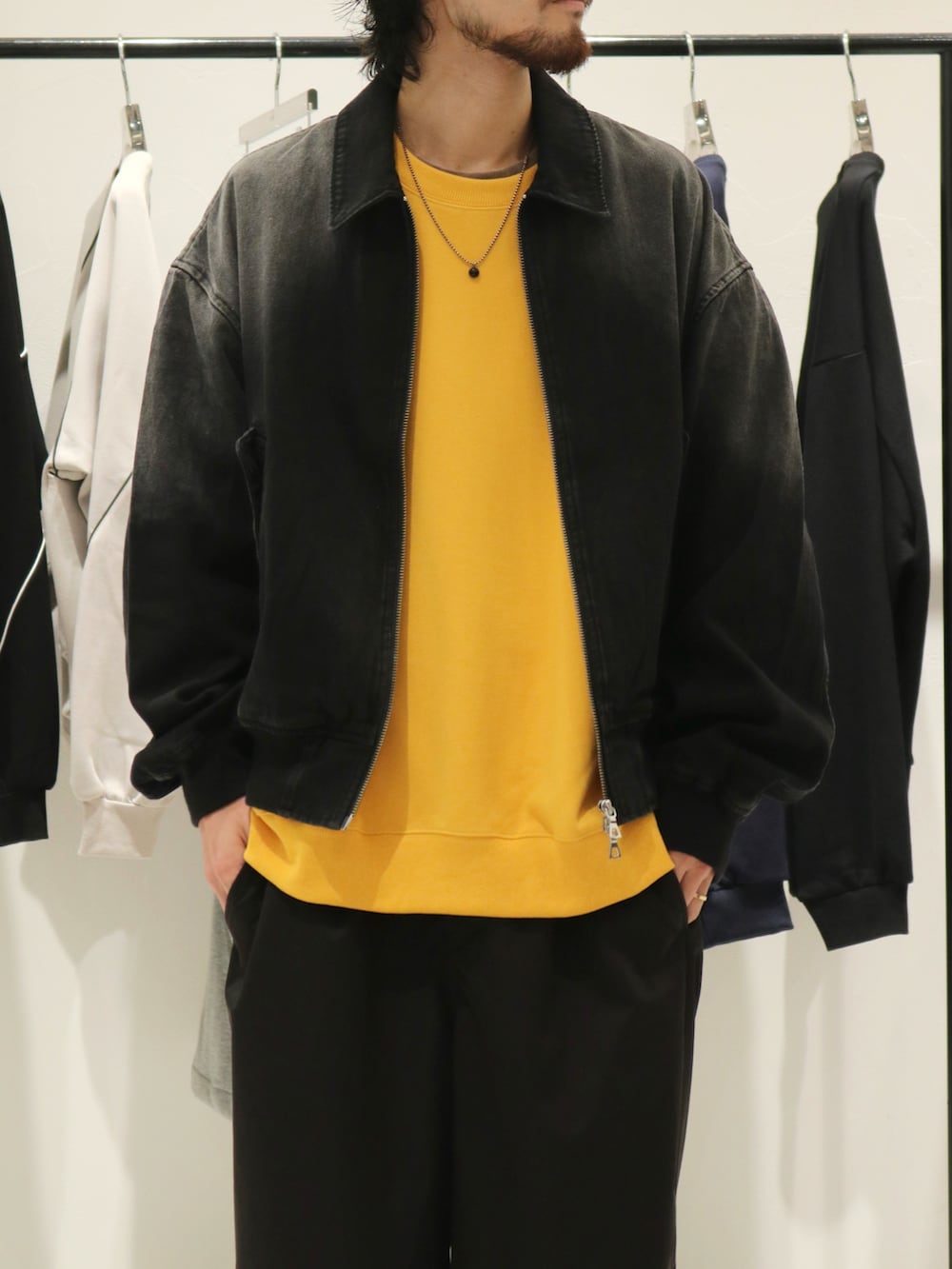 ブラック系のブルゾン、ブラック系のスニーカー、イエロー系のスウェットを着用したメンズの秋コーディネートの3枚目の写真
