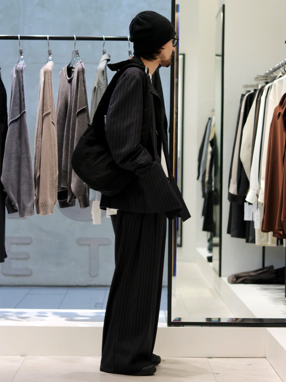 ブラック系のテーラードジャケット、ホワイト系のTシャツ/カットソー、ブラック系のスラックスを着用したメンズの秋コーディネートの2枚目の写真