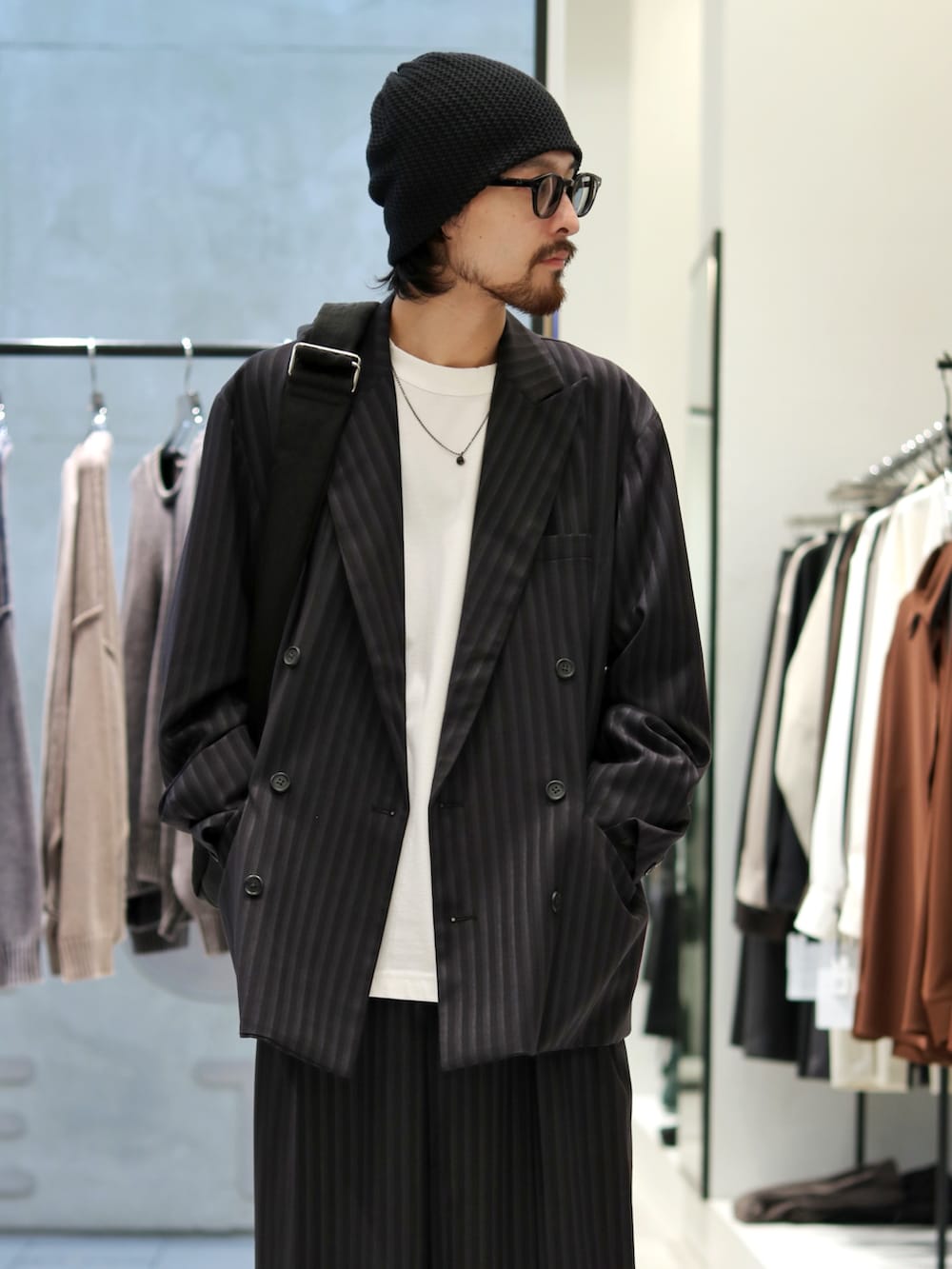 ブラック系のテーラードジャケット、ホワイト系のTシャツ/カットソー、ブラック系のスラックスを着用したメンズの秋コーディネートの3枚目の写真