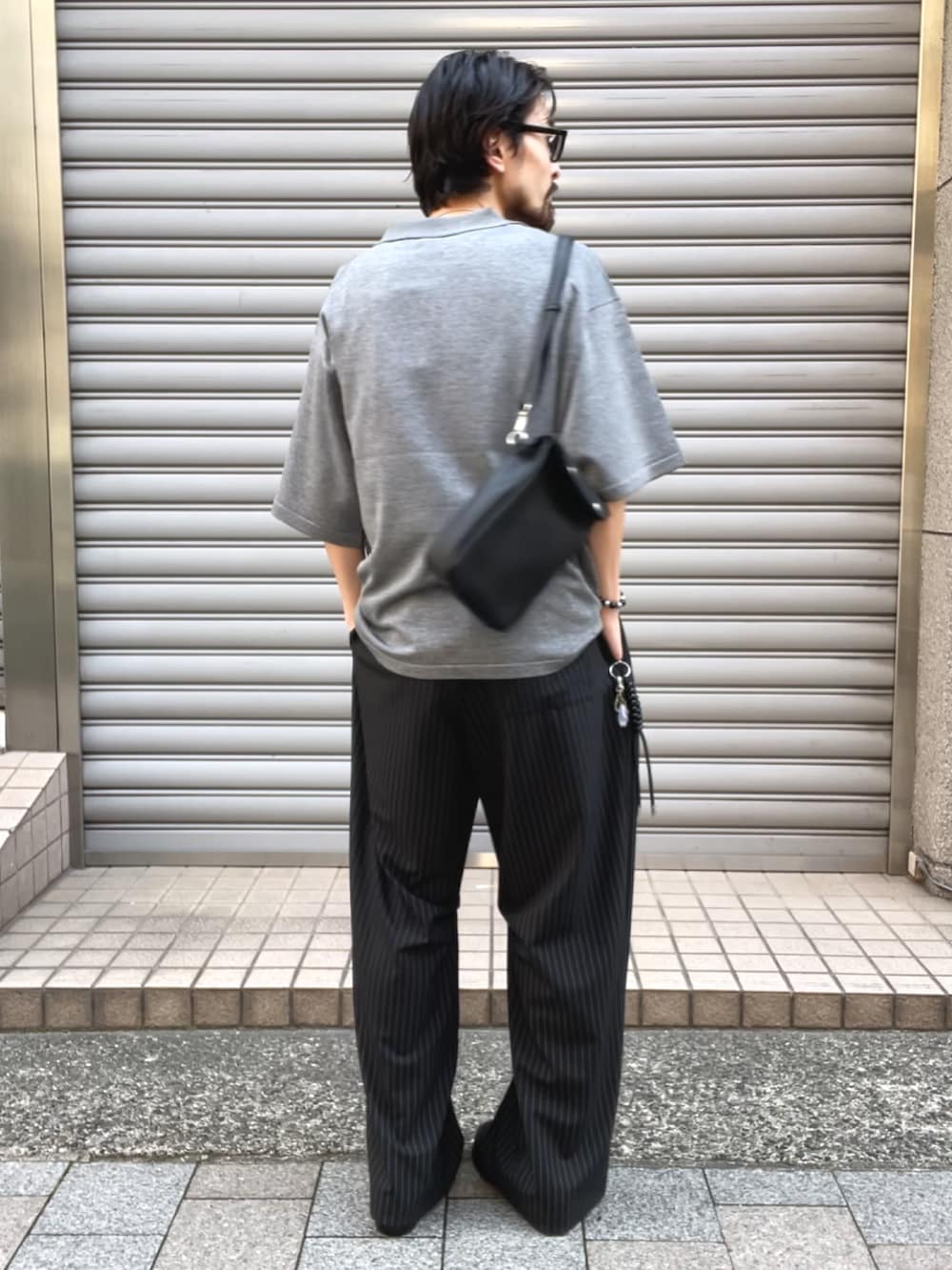 ブラック系のその他シューズ、グレー系のニット/セーター、ブラック系のショルダーバッグを着用したメンズの夏コーディネートの3枚目の写真