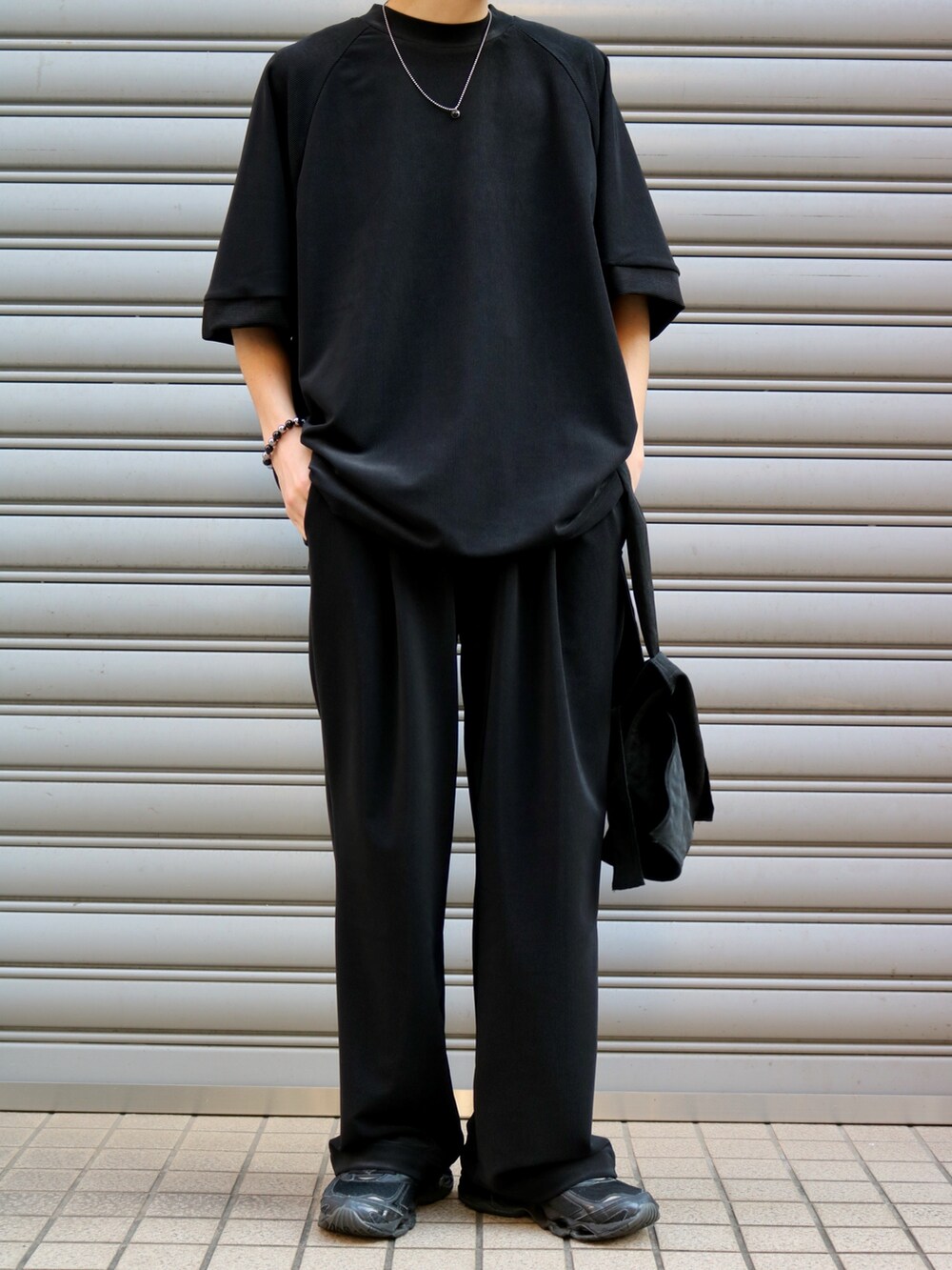 ブラック系のTシャツ/カットソー、ブラック系のトートバッグ、ブラック系のスラックスを着用したメンズの夏コーディネートの5枚目の写真