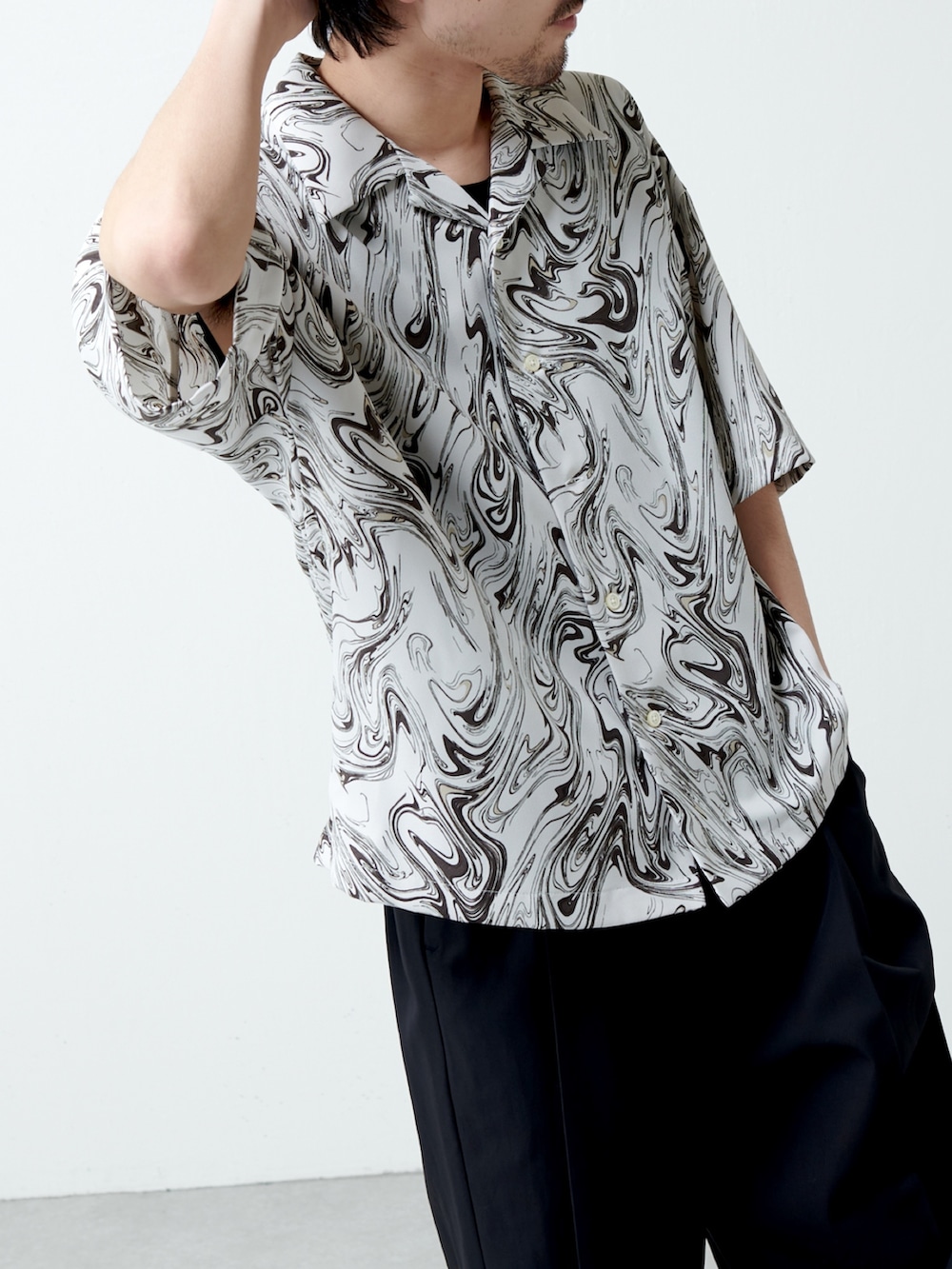 ブラック系のスラックス、ホワイト系のシャツ/ブラウスを着用したメンズの春コーディネートの2枚目の写真