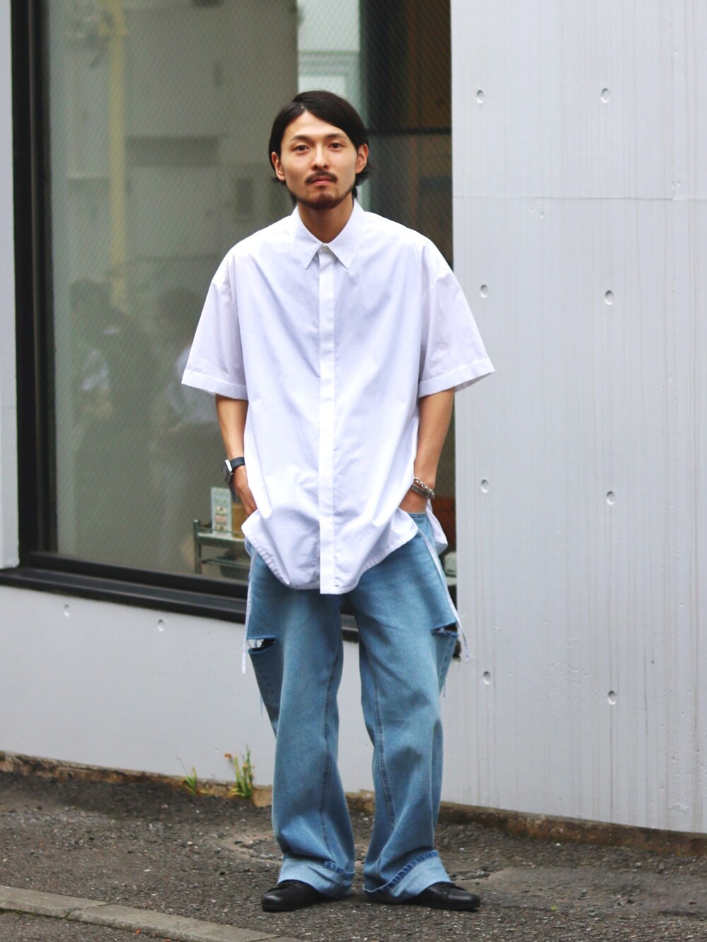 ブルー系のデニムパンツ、ブラック系のドレスシューズ、ホワイト系のシャツ/ブラウスを着用したメンズの夏コーディネートの3枚目の写真