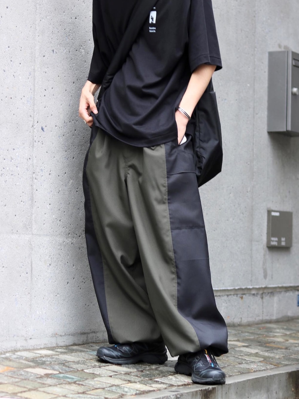 ブラック系のTシャツ/カットソー、ブラック系のスニーカー、グリーン系のカーゴパンツを着用したメンズの夏コーディネートの3枚目の写真