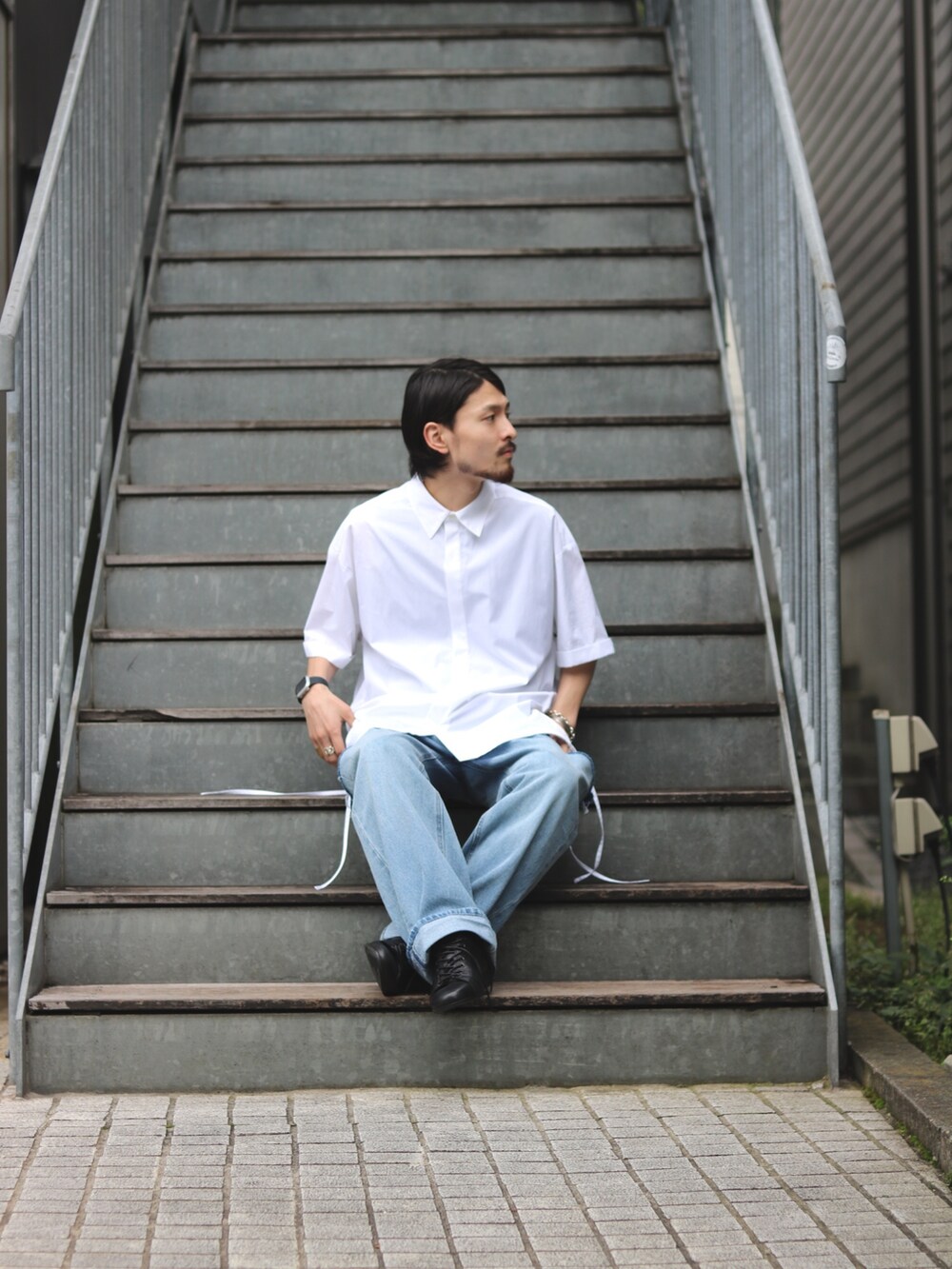 ブルー系のデニムパンツ、ブラック系のドレスシューズ、ホワイト系のシャツ/ブラウスを着用したメンズの夏コーディネートの2枚目の写真