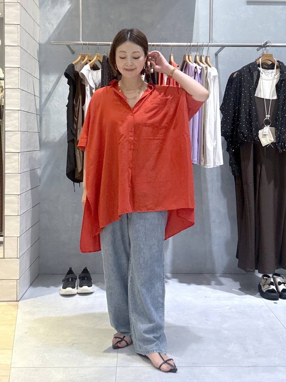 レッド系のシャツ/ブラウス、ブルー系のデニムパンツ、ゴールド系のネックレスを着用したレディースの夏コーディネートの2枚目の写真