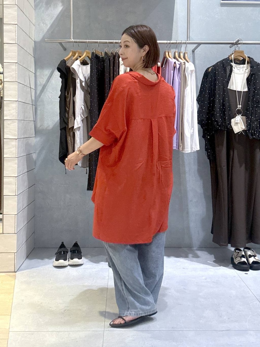 レッド系のシャツ/ブラウス、ブルー系のデニムパンツ、ゴールド系のネックレスを着用したレディースの夏コーディネートの4枚目の写真