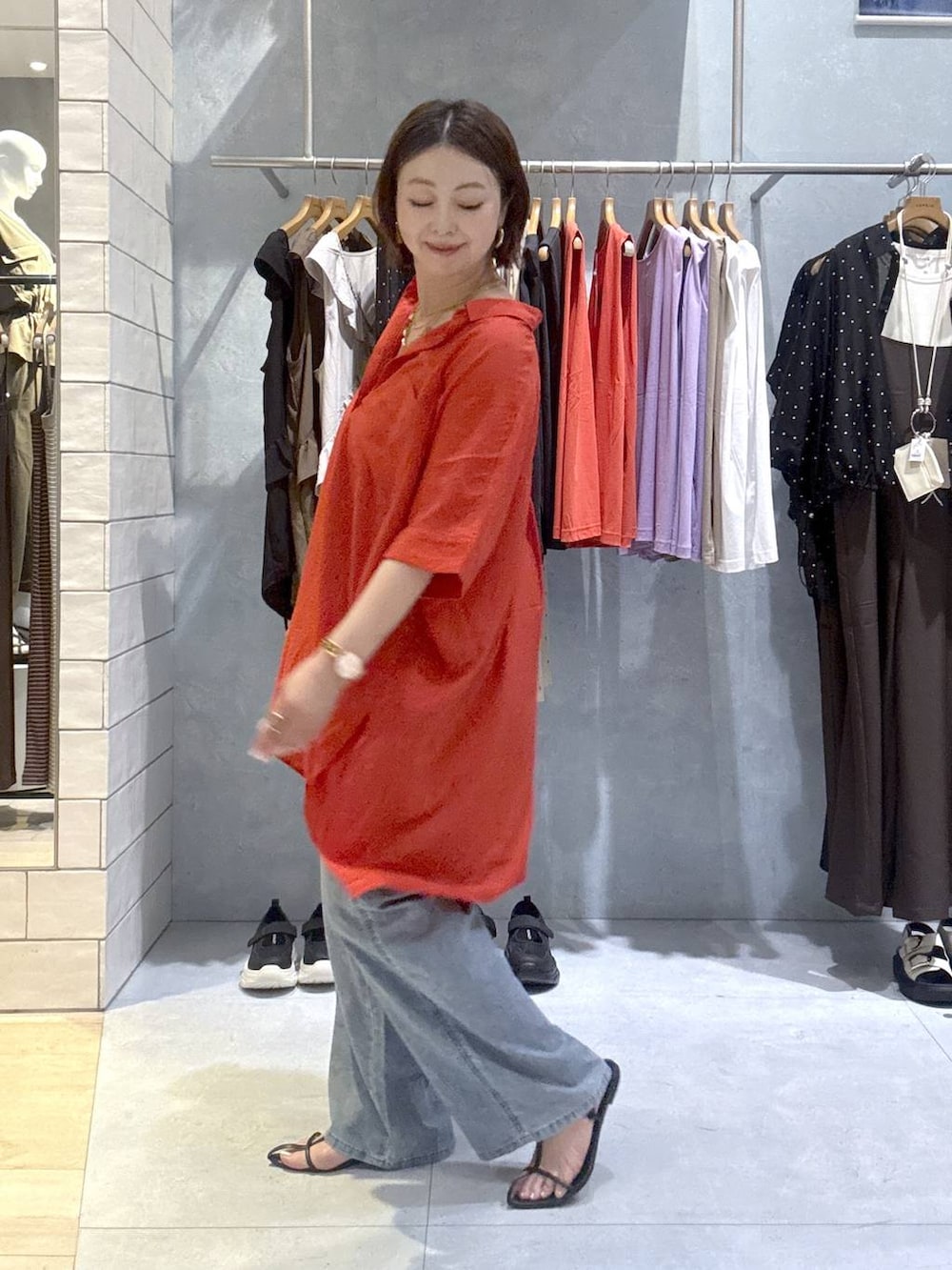 レッド系のシャツ/ブラウス、ブルー系のデニムパンツ、ゴールド系のネックレスを着用したレディースの夏コーディネートの3枚目の写真