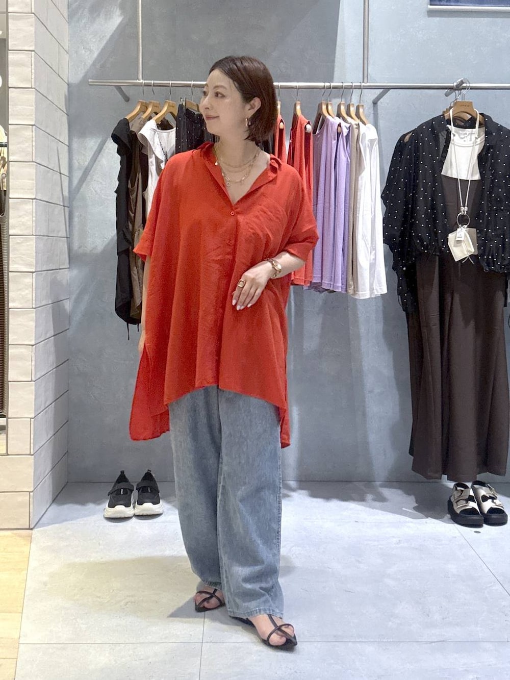 レッド系のシャツ/ブラウス、ブルー系のデニムパンツ、ゴールド系のネックレスを着用したレディースの夏コーディネートの5枚目の写真